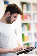 Image showing student in school library using tablet for research