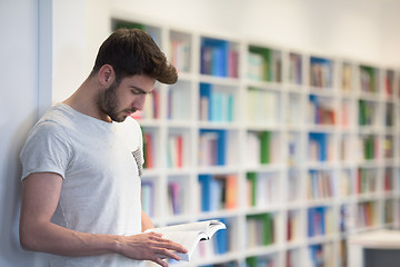 Image showing student in school library using tablet for research