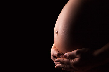 Image showing Pregnant woman silhouette over black background