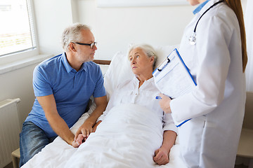 Image showing senior woman and doctor with clipboard at hospital