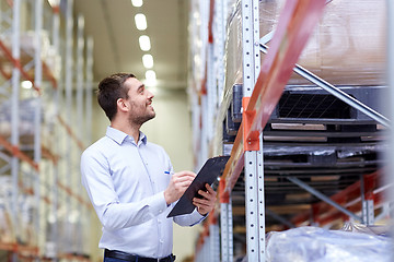 Image showing happy businessman with clipboard at warehouse