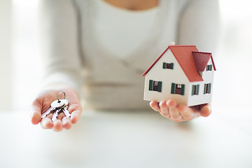 Image showing close up of hands holding house model and keys