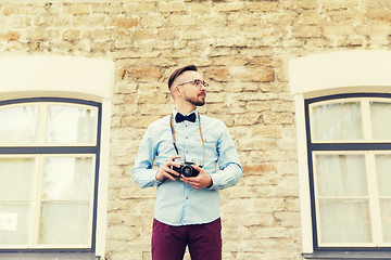 Image showing young hipster man with film camera in city
