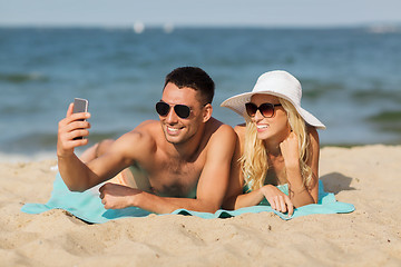 Image showing happy couple in swimwear walking on summer beach