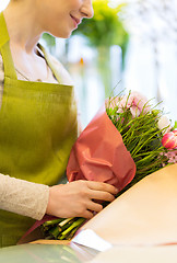 Image showing close up of woman packing bunch at flower shop