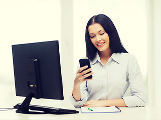 Image showing smiling businesswoman or student with smartphone