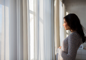 Image showing close up of happy pregnant woman looking to window