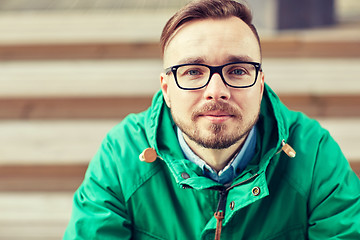 Image showing happy young hipster man sitting on stairs in city