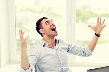 Image showing happy businessman with laptop in office