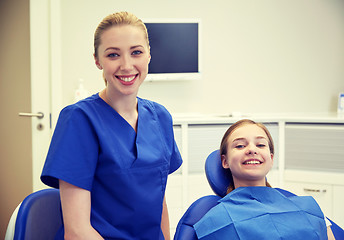 Image showing happy female dentist with patient girl at clinic