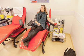 Image showing Donor in an armchair donates blood