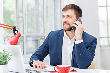 Image showing Portrait of businessman talking on phone in office