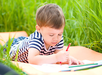 Image showing Little boy is playing with pencils