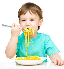 Image showing Little boy is eating spaghetti