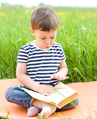 Image showing Little boy is reading book