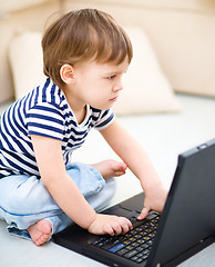 Image showing Little boy is playing on laptop