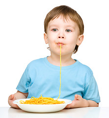 Image showing Little boy is eating spaghetti