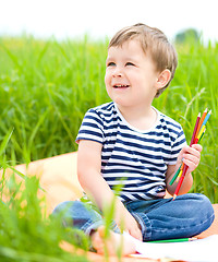 Image showing Little boy is playing with pencils