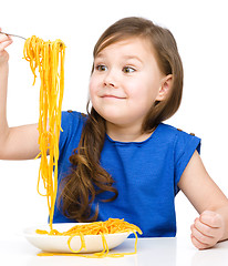 Image showing Little girl is eating spaghetti