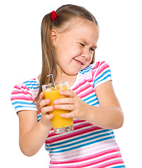 Image showing Little girl unwillingly drinking orange juice