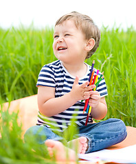 Image showing Little boy is playing with pencils