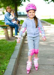 Image showing Happy little girl is skating on rollers