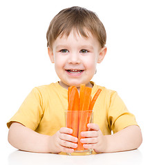 Image showing Little boy is eating carrot