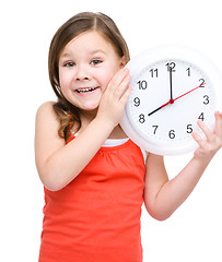 Image showing Little girl is holding big clock