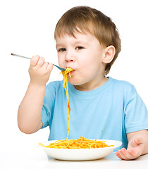 Image showing Little boy is eating spaghetti