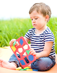 Image showing Little boy is playing with toys