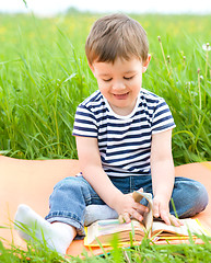 Image showing Little boy is reading book