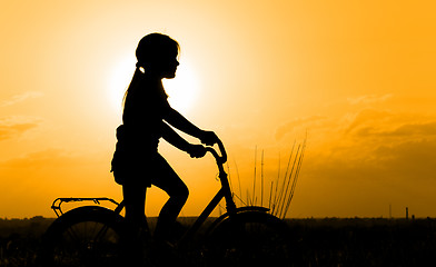 Image showing Silhouette of little girl on a bicycle