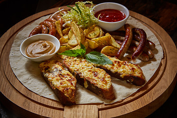 Image showing Assorted fried sausages, grilled potatoes, sauce Adjika, Mustard Sauce