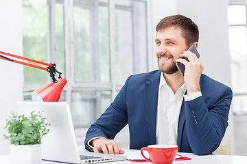 Image showing Portrait of businessman talking on phone in office