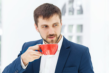 Image showing Businessman having coffee break, he is holding a cup 