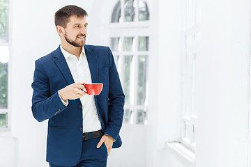 Image showing Businessman having coffee break, he is holding a cup 