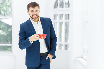 Image showing Businessman having coffee break, he is holding a cup 