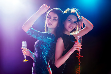 Image showing Two beautiful girls dancing at the party drinking champagne
