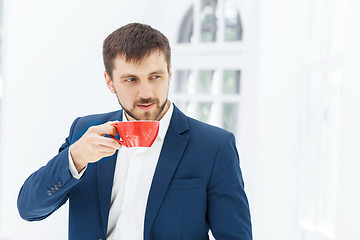 Image showing Businessman having coffee break, he is holding a cup 