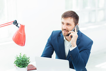 Image showing Portrait of businessman talking on phone in office