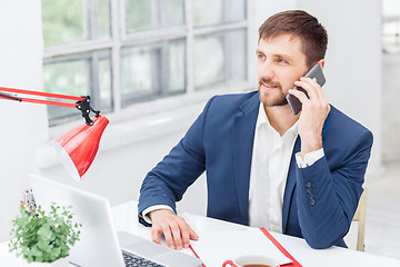 Image showing Portrait of businessman talking on phone in office