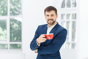 Image showing Businessman having coffee break, he is holding a cup 