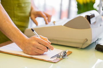 Image showing close up of man with clipboard at flower shop