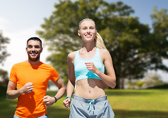 Image showing smiling couple running over summer park background