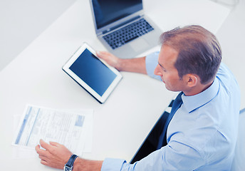 Image showing businessman with tablet pc and papers in office