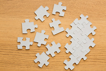 Image showing close up of puzzle pieces on wooden surface