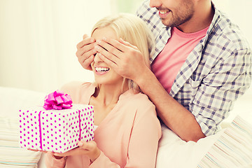 Image showing happy man giving woman gift box at home