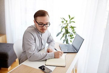 Image showing creative man or businessman writing to notebook