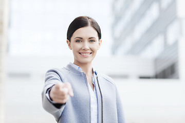 Image showing young smiling businesswoman over office building