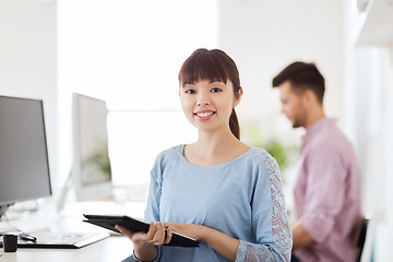 Image showing happy creative female office worker with tablet pc